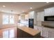 Bright kitchen with an island, modern appliances, white cabinets, and hardwood flooring at 16156 Oliver St, Fishers, IN 46037