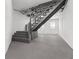 Basement stairs leading to a concrete floor with white-painted walls and a distant window at 1630 N Granville N Ave, Muncie, IN 47303
