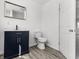 Stylish bathroom with a dark vanity, white walls, toilet, and a door to another room at 1630 N Granville N Ave, Muncie, IN 47303