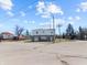 Two story commercial building with a gray and white exterior, garage doors and manicured landscaping at 1630 N Granville N Ave, Muncie, IN 47303