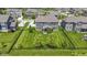 Aerial view of a home's backyard featuring lush grass, mature trees, and a black fence, offering privacy and space at 16305 Kenora N Ln, Fortville, IN 46040