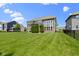 Spacious backyard showcasing manicured lawn, mature trees, and beautiful architectural details at 16305 Kenora N Ln, Fortville, IN 46040