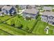 Aerial view of a large backyard featuring a lush lawn, mature trees, a playset and enclosed with a black fence at 16305 Kenora N Ln, Fortville, IN 46040