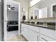 Bathroom with a double vanity, white cabinets, a dark countertop, and a view into a bedroom at 16305 Kenora N Ln, Fortville, IN 46040