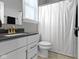 Bathroom featuring a white shower curtain, toilet, and dark vanity with white cabinets at 16305 Kenora N Ln, Fortville, IN 46040