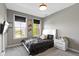Bedroom with two windows, grey walls, and carpet. A TV is mounted on the wall at 16305 Kenora N Ln, Fortville, IN 46040