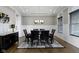 Elegant dining room with a modern chandelier, tray ceilings, and a sleek table with six chairs at 16305 Kenora N Ln, Fortville, IN 46040
