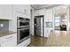 Close-up of modern kitchen appliances including double ovens, a stainless steel refrigerator and granite countertops at 16305 Kenora N Ln, Fortville, IN 46040