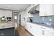 Modern kitchen featuring white cabinets, granite countertops, stainless steel appliances and a light blue tile backsplash at 16305 Kenora N Ln, Fortville, IN 46040