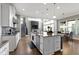 Open concept kitchen features a central island with granite countertops, stainless steel appliances, and hardwood floors at 16305 Kenora N Ln, Fortville, IN 46040