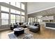 Sunlit open concept living room with view to the kitchen, featuring a modern sectional and large windows at 16305 Kenora N Ln, Fortville, IN 46040