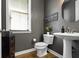 Modern powder room with a pedestal sink, stylish mirror, and dark, elegant wall color at 16305 Kenora N Ln, Fortville, IN 46040