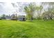 Expansive backyard featuring lush greenery, mature trees, a playset, and a storage shed, perfect for outdoor activities at 171 Williams Trce, Plainfield, IN 46168