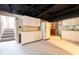 Basement kitchenette area with white cabinets, refrigerator, and stone accent wall at 171 Williams Trce, Plainfield, IN 46168