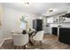 Bright dining area with modern table set, black refrigerator, and white cabinets at 1903 Danbury Dr, Indianapolis, IN 46231
