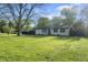Well-manicured front yard with a ranch home, mature trees, and lush greenery at 1903 Danbury Dr, Indianapolis, IN 46231