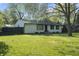 Quaint home with a lush green lawn, mature trees, and a welcoming entrance at 1903 Danbury Dr, Indianapolis, IN 46231