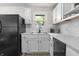 Bright kitchen features white cabinets, subway tile backsplash, stainless steel sink, and black refrigerator at 1903 Danbury Dr, Indianapolis, IN 46231