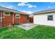 Backyard with green grass, brick house, white garage, and blue skies at 1964 Mann Dr, Beech Grove, IN 46107