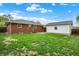 Green backyard featuring a detached garage and a brick home at 1964 Mann Dr, Beech Grove, IN 46107
