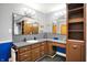 Bathroom featuring double sinks, storage cabinets, and a shower at 1964 Mann Dr, Beech Grove, IN 46107