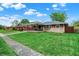 Quaint single-story home with a covered porch and vibrant green lawn, complemented by a sidewalk at 1964 Mann Dr, Beech Grove, IN 46107