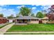 Charming single-story brick home featuring a cozy front porch and a well-manicured lawn at 1964 Mann Dr, Beech Grove, IN 46107