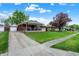 A single-story home featuring a covered front porch with lush lawn and a detached garage at 1964 Mann Dr, Beech Grove, IN 46107