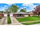 Charming single-story brick home featuring a cozy front porch, detached garage, and well-manicured lawn at 1964 Mann Dr, Beech Grove, IN 46107