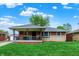 A cozy single-story home features a covered porch and well-manicured front lawn under a partly cloudy sky at 1964 Mann Dr, Beech Grove, IN 46107