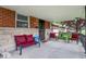 Inviting covered front porch with comfortable seating, brick accents and charming decorative details at 1964 Mann Dr, Beech Grove, IN 46107