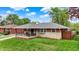 Charming home featuring a stone facade, covered porch, and lush green lawn at 1964 Mann Dr, Beech Grove, IN 46107