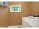 Convenient laundry room includes a washer, dryer, and a window for natural light at 1964 Mann Dr, Beech Grove, IN 46107