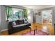 Warm living room featuring hardwood floors, a comfortable sofa, and an open view to the dining area at 1964 Mann Dr, Beech Grove, IN 46107