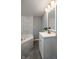 Bathroom featuring a tub with marble surround and a vanity with a large mirror at 201 N 5Th St, Elwood, IN 46036