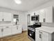 Charming kitchen featuring white cabinets, stainless steel appliances, and modern fixtures at 2015 S Hackley St, Muncie, IN 47302