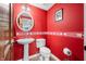 A red themed powder room with pedestal sink and elongated toilet at 2015 Saint Andrews Ct, Franklin, IN 46131