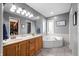 Bathroom featuring a walk-in closet, tile floors, corner tub, and dual vanities at 2015 Saint Andrews Ct, Franklin, IN 46131