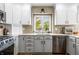 Functional kitchen showcasing stainless steel appliances, gray backsplash, and white cabinets for storage and style at 2015 Saint Andrews Ct, Franklin, IN 46131