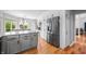 Modern kitchen featuring gray cabinets, granite countertops, stainless steel appliances, and adjacent dining area at 2015 Saint Andrews Ct, Franklin, IN 46131