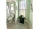 Bathroom with mint green paint, a black plant stand, and a window at 2119 S Garfield Dr, Indianapolis, IN 46203