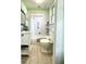 Bathroom with mint green paint, white bathtub and tile, and a window at 2119 S Garfield Dr, Indianapolis, IN 46203