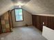 Attic featuring finished floor, wood paneling, and a window at 2271 Park Ave, Columbus, IN 47201