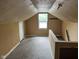 An attic with finished floors, neutral paint, and a small window at 2271 Park Ave, Columbus, IN 47201