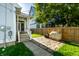 Fenced backyard with stone patio, covered grill, stone path, partial view of the home with steps, and green grass at 2306 Alabama St, Indianapolis, IN 46205