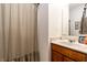 Updated bathroom with marble counters, wooden vanity, stylish mirror and shower with curtain at 2306 Alabama St, Indianapolis, IN 46205