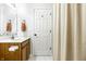 Bright bathroom featuring white tile flooring, a wooden vanity, and a shower with neutral curtain at 2306 Alabama St, Indianapolis, IN 46205