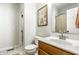 Well-lit bathroom features a toilet, sink with a marble countertop, wooden cabinetry and decorative wall art at 2306 Alabama St, Indianapolis, IN 46205
