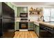 Well-lit kitchen with sage colored cabinets, floating shelves, butcher block counters, and stainless steel appliances at 2306 Alabama St, Indianapolis, IN 46205