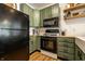 Sage colored kitchen with butcher block counters, floating shelves, and stainless steel appliances at 2306 Alabama St, Indianapolis, IN 46205